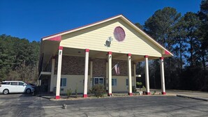 A building with a covered entrance, columns, and an American flag.