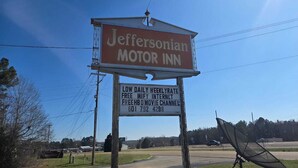 A motel sign with amenities including low daily rate, free WiFi, internet, and a free movie channel. - 2 Queen Beds Non-Smoking (Prentiss, MS)