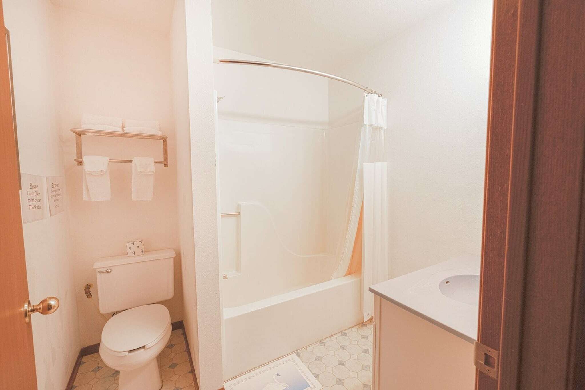 Un baño con inodoro, bañera y cortina de ducha.