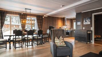 Amplia sala de estar con mesa de comedor, sillas, sofá y zona de cocina.