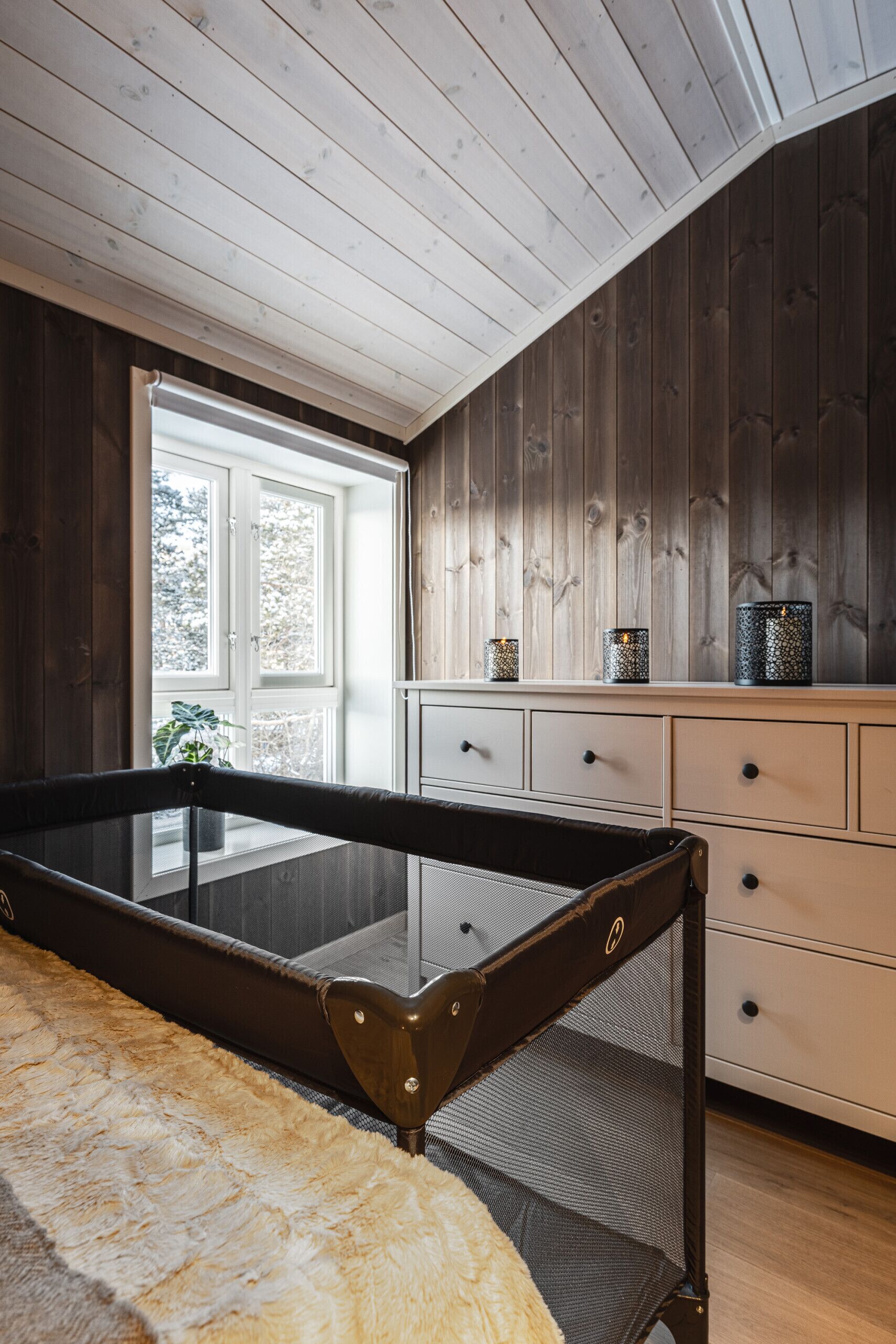 Une pièce avec une table de billard, une fenêtre donnant sur un beau paysage, une commode et une plante.
