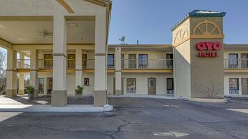 Un hôtel doté d’une entrée couverte, de plusieurs balcons et d’une enseigne indiquant « HÔTEL OYO ».