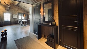 Ein Holzinnenraum mit Essbereich, Kamin und einer Tür mit Spiegel.