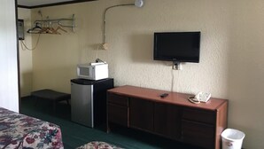 A hotel room with a bed, a desk with a microwave, a TV, a telephone, and a clothes drying rack. - 2 Full Beds Non-Smoking (Wathena, KS)