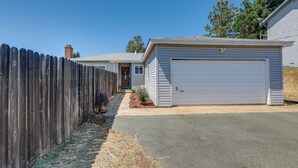Ein Wohnhaus mit Garage, Holzzaun und Auffahrt.