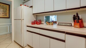 A kitchen with white cabinets, a white refrigerator, and a 'BIENVENUE' sign on the counter. - Island Walk to Ocean, Dining w/ Boat Dock & Lift! (Jensen Beach)