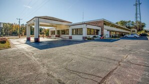 A gas station with a canopy, a building with large windows, and a tall communication tower in the background. - 2 Full Bed|Smoking|Petersburg VA (Petersburg VA)