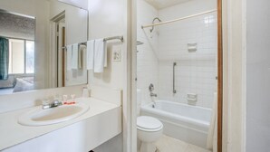 A bathroom with a sink, mirror, toilet, and bathtub. - 2 Full Bed|Smoking|Petersburg VA (Petersburg VA)
