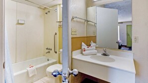A bathroom with a bathtub, toilet, sink, and a mirror. - Pensacola FL | 2 Full Bed (Pensacola FL)
