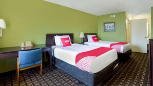 A hotel room with two beds, a desk, a chair, and a picture on the wall. - Pensacola FL | 2 Full Bed (Pensacola FL)