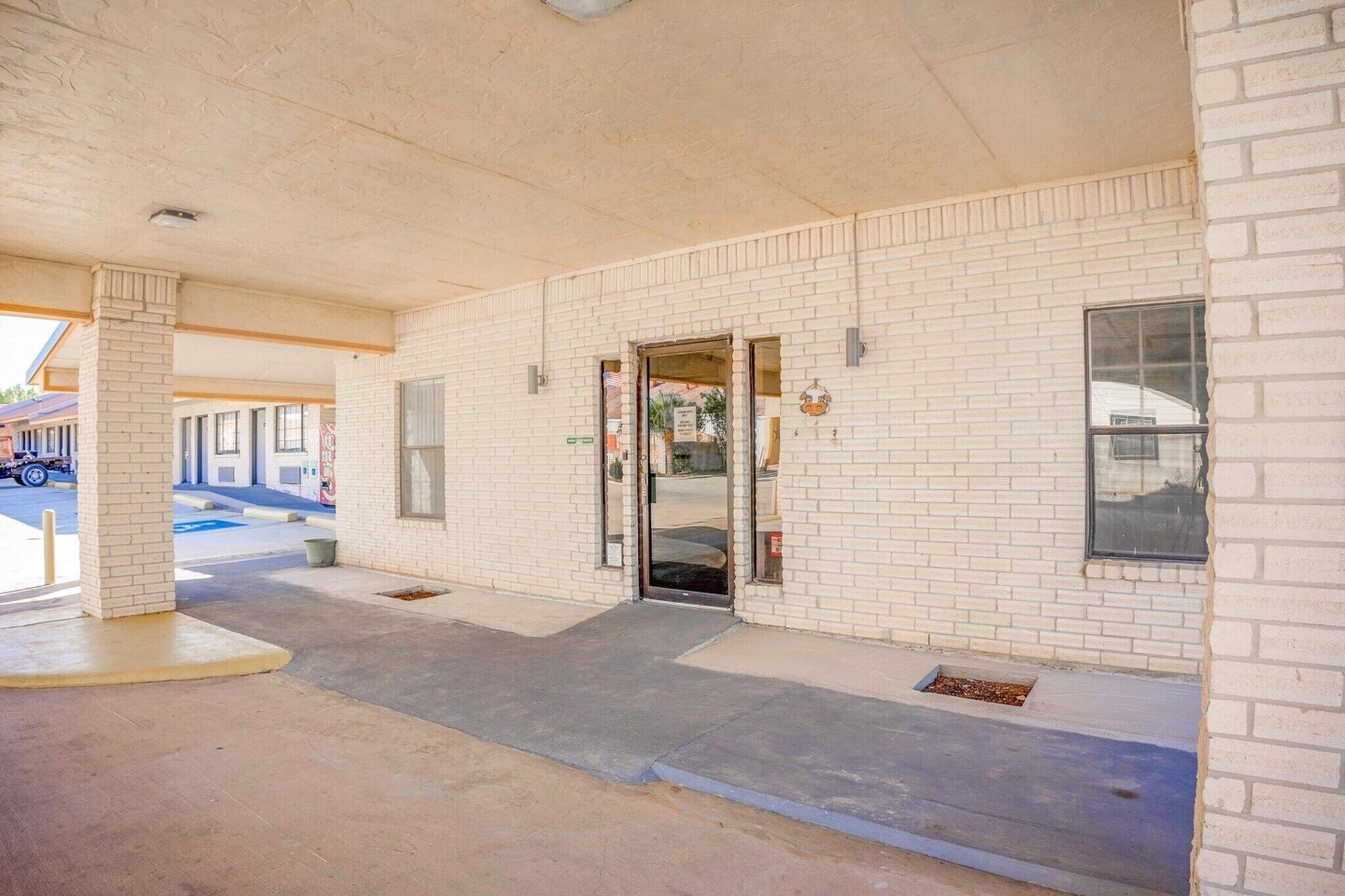 Un edificio de fachada de ladrillo, una puerta y un ventanal.