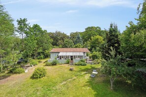 A house with a red roof, surrounded by trees and a grassy yard. - Holiday Close to Forest, Fjord and Beach (Kulhuse)