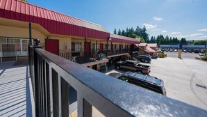 Un motel avec un toit rouge, de nombreuses places de stationnement et une devanture bien visible.
