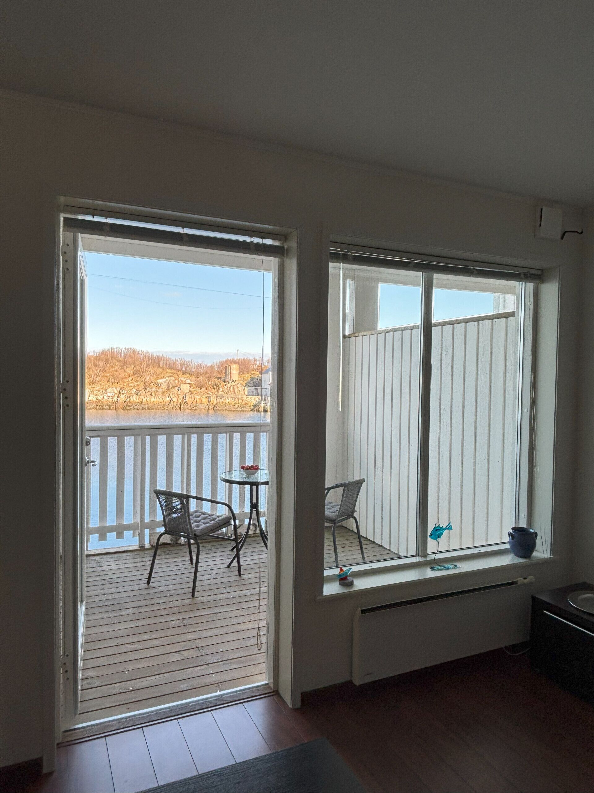 A room with a sliding glass door leading to a balcony with outdoor furniture.