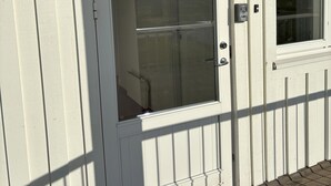 Un edificio blanco con una puerta marcada con el número 203 y una ventana.
