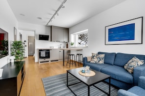A modern living space with a kitchen, a dining area, and a seating area with a sofa and coffee table. - Northern Luxe Retreat (Tromsø)
