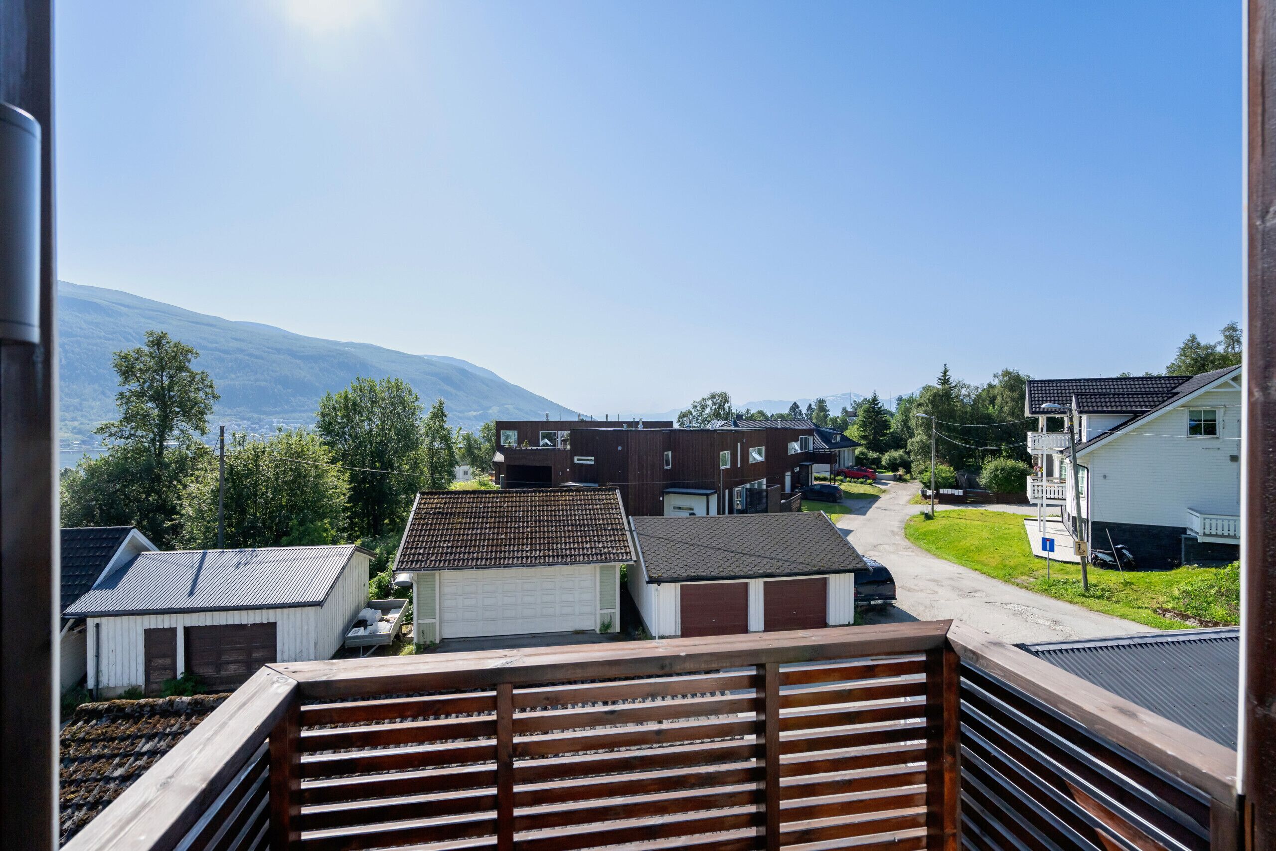 Ein Wohngebiet mit Häusern, einer Garage und einem Berg im Hintergrund.