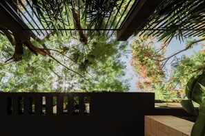 A view through a window with a metal frame, looking out to a garden with trees and a fence. - Olive & Oak Residence I Nesty Hospitality (Al Maadi)
