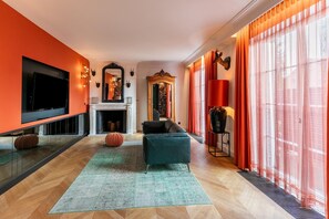 Un salon moderne avec une cheminée, un téléviseur et un canapé.