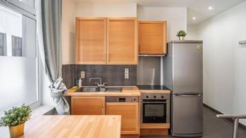 Una cocina moderna con armarios de madera, un refrigerador de acero inoxidable y un lavavajillas.