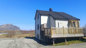 Une maison de plain-pied avec un balcon, une cheminée et une vue sur une montagne.