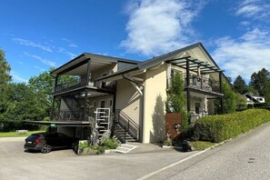 Ein zweistöckiges Haus mit Balkon, Garage und einer Treppe, die zum Obergeschoss führt.