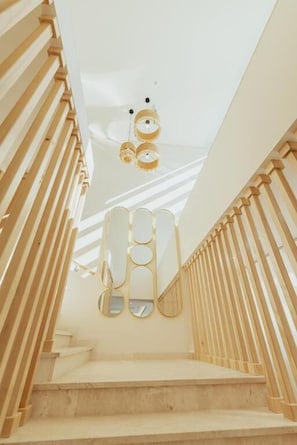 A staircase with wooden railings and a ceiling with circular light fixtures.