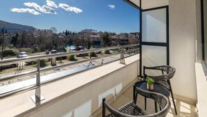 A balcony with a view of a river, a bridge, and distant buildings. - Hotel Orjen Sport&Pleasure (Trebinje)