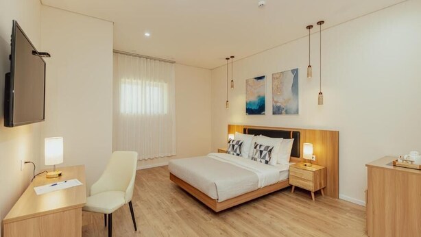 A hotel room with a bed, bedside tables, a desk, a chair, a TV, and artwork on the wall. - Hotel Orjen Sport&Pleasure (Trebinje)