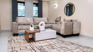 Ein Wohnzimmer mit einer Eckcouch, einem Couchtisch und einem großen Spiegel an der Wand.