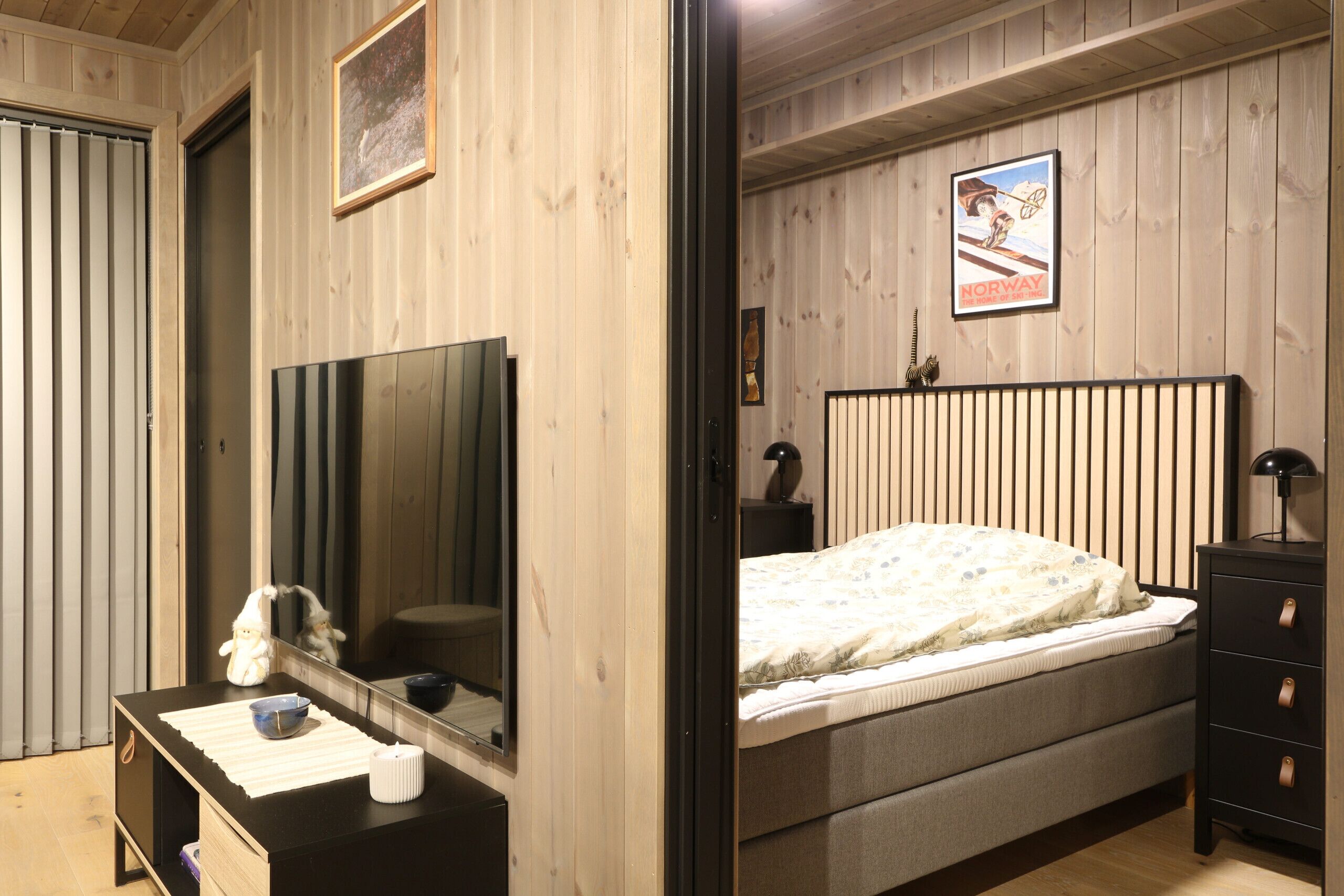 Un dormitorio con cama, cómoda, espejo y un cartel en la pared.