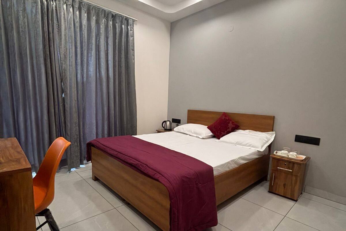 Ein Schlafzimmer mit Bett, Schreibtisch, Stuhl, Nachttisch und Deckenventilator.