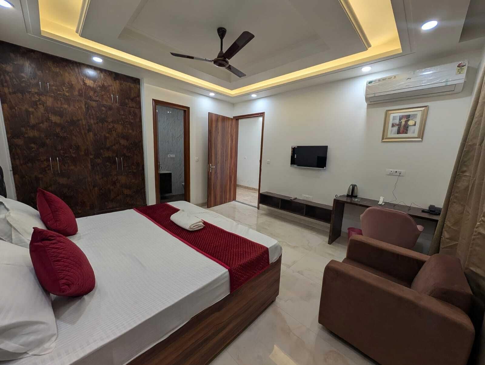 Une chambre d’hôtel équipée d’un lit, d’un coin salon, d’une télévision et de la climatisation.
