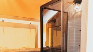 Uma casa de banho moderna com cabine de duche em vidro, soalho em madeira e sanita branca.