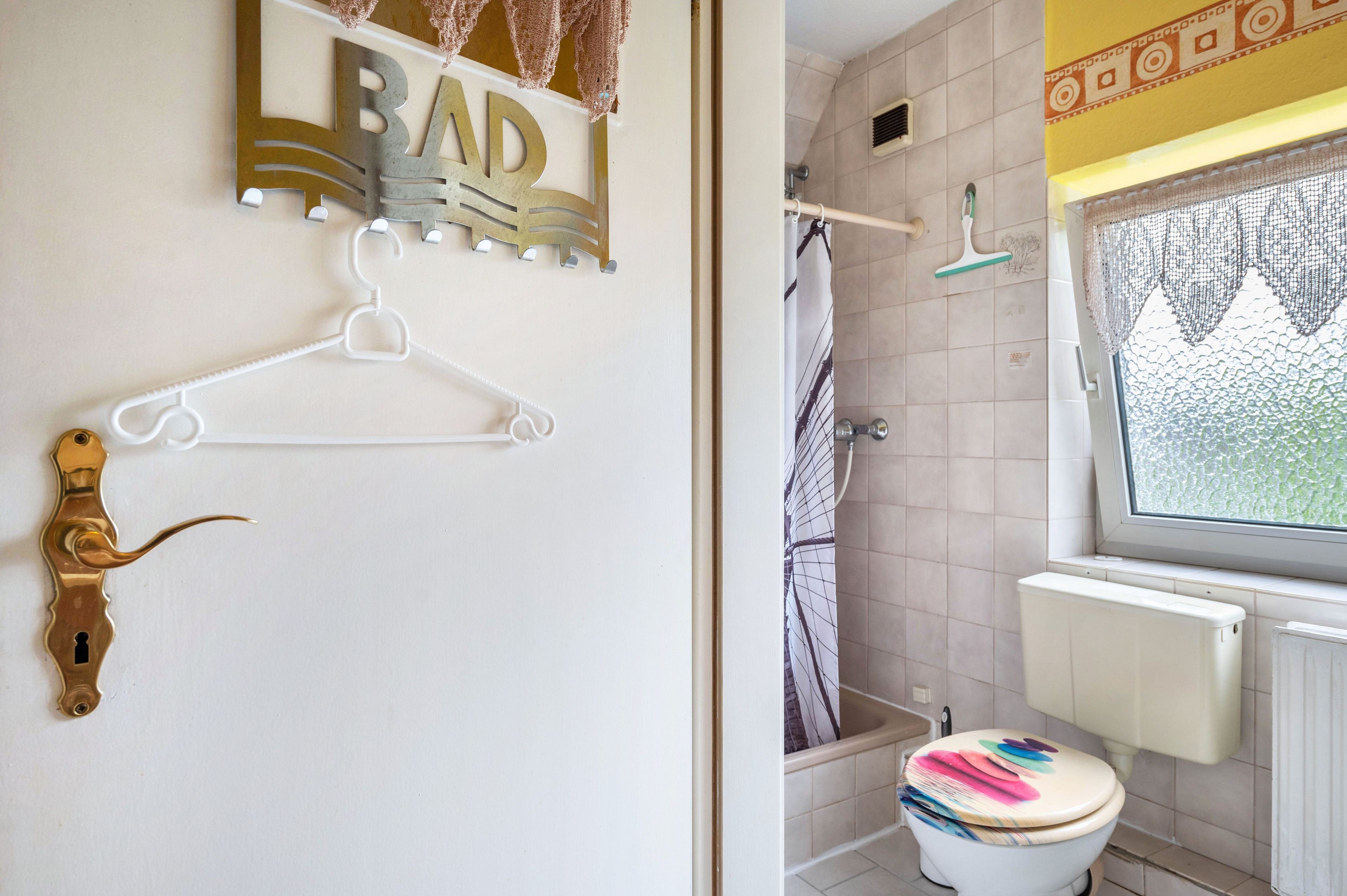 Ein Badezimmer mit Toilette, Dusche und einem Fenster.