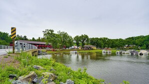 Une vue sur la rivière, avec un pont en bois, des bateaux et des bâtiments en arrière-plan.