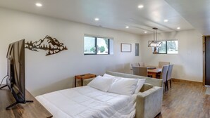 Une chambre moderne avec un lit, un bureau et une chaise. Un motif représentant une montagne décore le mur, et une fenêtre laisse entrer la lumière naturelle.