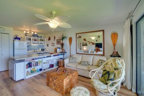 Ein kompakter Wohnraum mit Küchenzeile, Essbereich, Sofa und Sessel.