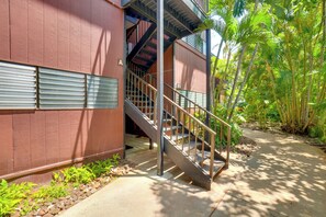 Ein Gebäude mit einer Treppe, die zu einer oberen Ebene führt, umgeben von viel Grün.