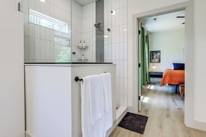 A modern bathroom with a glass shower enclosure, a white towel hanging on a wall-mounted rack, and a visible showerhead. - Deck & Fire Pit! Mtn Escape, 12 Mi to Asheville (Leicester)
