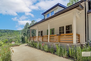 A building with a covered porch, a guest parking sign, and a view of a green landscape. - Deck & Fire Pit! Mtn Escape, 12 Mi to Asheville (Leicester)