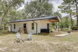 A single-story house with a porch, two white chairs, and a fire pit. - 6 Mi to Three Sisters Springs! Extended Getaway (Homosassa)