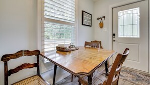 A dining room with a wooden table, chairs, a chandelier, and a window with blinds. - 6 Mi to Three Sisters Springs! Extended Getaway (Homosassa)