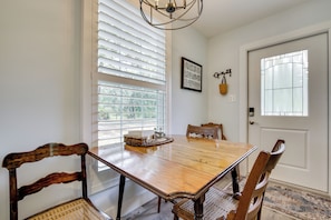A dining room with a wooden table, chairs, a chandelier, and a window with blinds. - 6 Mi to Three Sisters Springs! Extended Getaway (Homosassa)