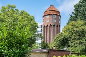 A brick tower with a conical roof, surrounded by lush greenery. - Holiday Apartment for 3 Guests (45 m²) in Brunsbüttel (Brunsbüttel)