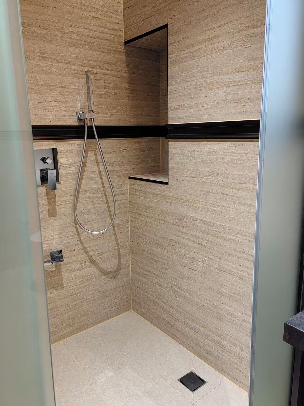 Un baño moderno con ducha, un espejo y un perchero para toallas.