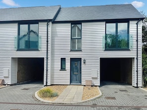 A two-story house with a garage, a front door, and a small garden area.