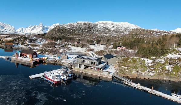 Un pueblo costero con un muelle, barcos y edificios.