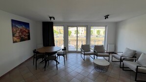 Ein Wohnzimmer mit Esstisch, Stühlen, einer Couch und einem Gemälde an der Wand.