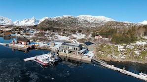 A coastal village with a dock, boats, and buildings. - Valen Brygge, Digermulen (Vågan)